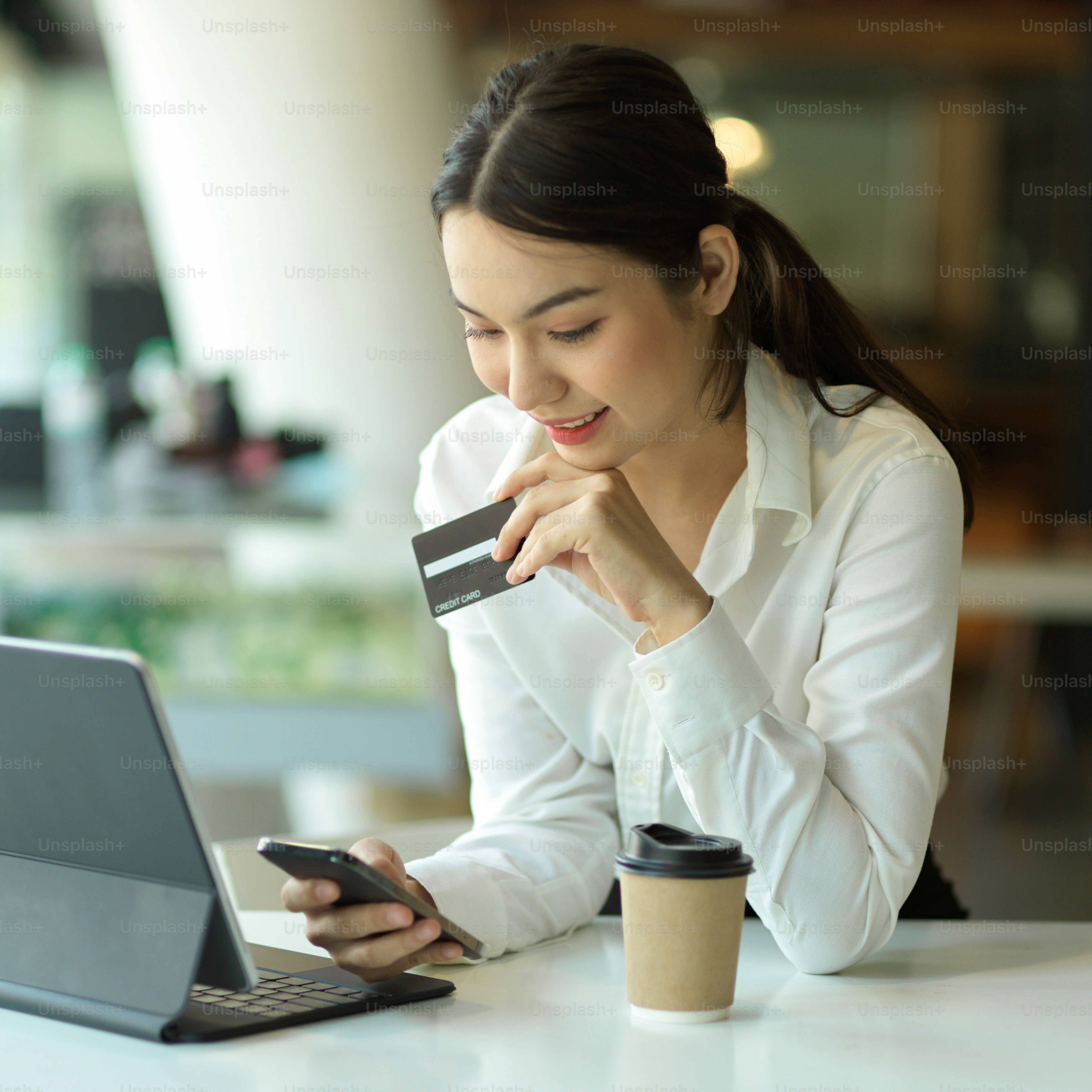 Portrait of happy female office worker shopping on digital tablet and online paying with credit card